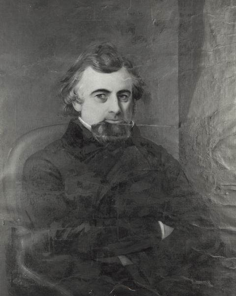 Waist-up portrait of William A. Barstow sitting in a chair with his arms crossed. He is looking to the left.