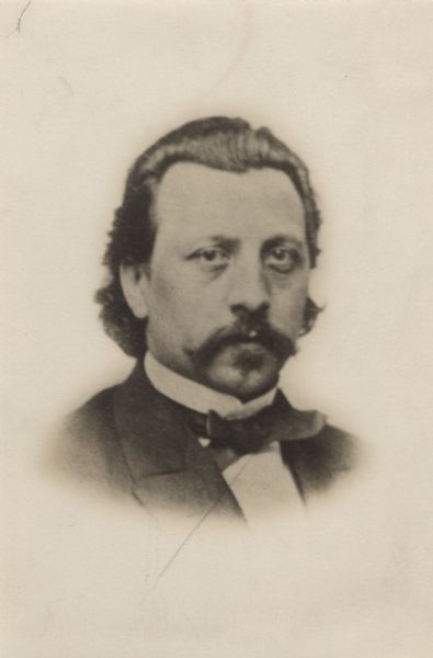 Head and shoulders studio portrait of Edward Salomon wearing a suit and tie.