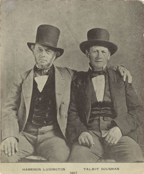 Portrait of Harrison Ludington, the future 13th governor of Wisconsin (left) and Talbot C. Dousman (right). They are both wearing top hats and suits. They are sitting side-by-side, and Ludington has his left arm around Dousman's shoulder.