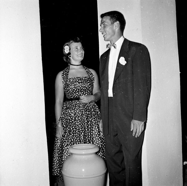 Audrey Hobbins and Bill Marshall standing on the porch of the Maple Bluff Country Club while attending a social event for teens.