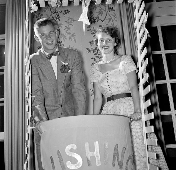 Dick Ragatz and Sally Tisdale stand behind a "wishing well" decoration at the Maple Bluff Country Club party.