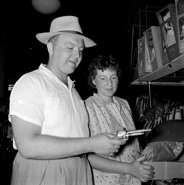 After Governor Kohler signed legislation legalizing the sale of caps and cap pistols, many youth prepared to celebrate the Independence Day holiday with the new toys. William Marx and his wife buy a cap pistol for their son, Robert.