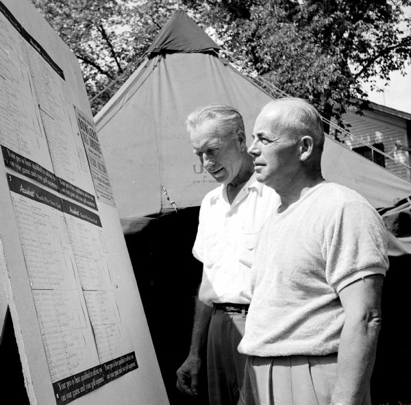 Everett Robinson (left), Lake Ripley Country Club, Cambridge, and William Rhyme, Portage Country Club, examine the scoreboard before starting their senior division final championship match of the 31st annual East-Central Wisconsin Golf Association tournament held at the Koshkonong Mounds Country Club in Fort Atkinson. Robinson won 2 and 1 and was awarded the H. B. Rogers Trophy.