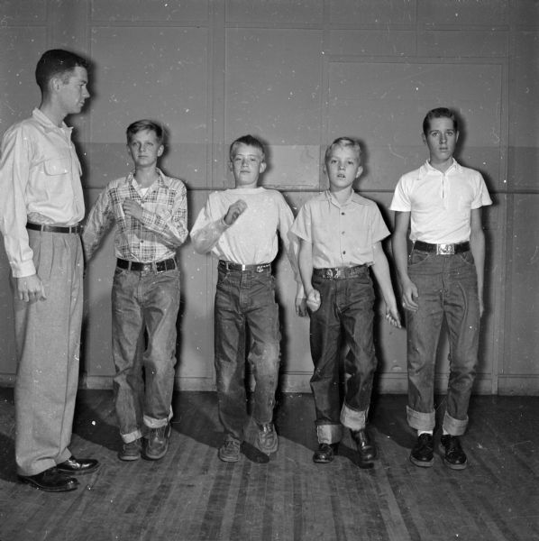 Instructor Stan Stitgen of the Four Lakes Council Boy Scout Drum and Bugle Corps gives marching cadence lessons during a junior corps rehearsal. Students include, left to right: Lavern Wohlin, 318 W. Lakeside Street; Harold Joyce, 509 S. Owen Drive; and Richard Dix, 854 Terry Place.The boy on the far right is unidentified. The boys rehearse once a week.