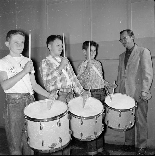 Instructor Henry Johnson of the Four Lakes Council Boy Scout Drum and Bugle Corps checks technique of the junior drum and bugle corps members Jim Archer, 1906 West Lawn Avenue, David Entwistle, 4123 Jerome Street, and Peter Moran, 1237 East Wilson Street. Junior corps members are 11 to 13 years old.