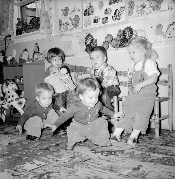 At Mrs. V.B. Roberts' nursery school, children play games in celebration of Thanksgiving Day. Twins Gretchen and Christine Wilkie are pretending to be turkeys in the foreground. Behind them are Stephanie Stevens, Charles Gearhart and Martha Johnson.