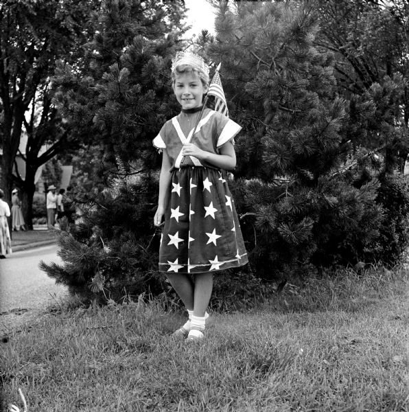 Dressed in a star spangled skirt and holding an American flag over her shoulder, this little girl's costume emphasizes the real meaning of the Fourth of July.