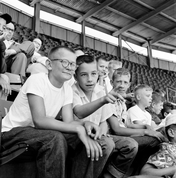 Wisconsin State Journal newspaper carriers attend the Milwaukee Braves versus St. Louis Cardinals baseball game. Rudy Laue (eft), Jim Shippley, and David Asche attend the game.