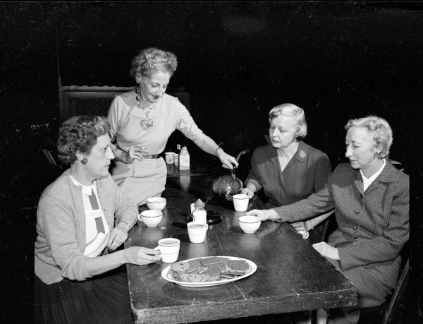Women of the Elk prepare materials for distribution for the 1954 Christmas seal drive honoring the 50th anniversary of the National Anti-Tuberculosis Association. Taking a coffee break are, (left to right): Mrs. Thomas McMahon, 526 W. Shore Drive: Mrs. C.A. Grant, 145 Dunning Street, co-chairman of the envelope project; Mrs. Walter Lillesand, 2733 Rose Street; and Mrs. J.B. Hermsen, 516 N. Pinckney Street, chairman of the drive.