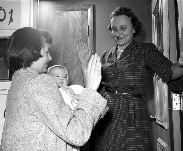Women in a neighborhood near Dean Avenue are studying sign language so that more deaf women can join their homemakers' club. Mrs. Robert Ilten is greeted in sign language by the hostess Mrs. Olin Jacobsen.