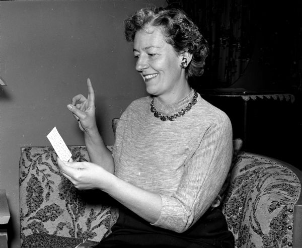 Women in a neighborhood near Dean Avenue study sign language so that more deaf women can join their homemakers' club. Mrs. James Stockton studies the sign language alphabet.