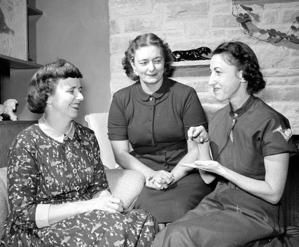 Women in a neighborhood near Dean Avenue study sign language so that more deaf women can join their homemakers club. Chatting through sign language are, left to right: Mrs. Russell Jensen, Mrs. Raymond Malec and Mrs. Clarence Hartley.