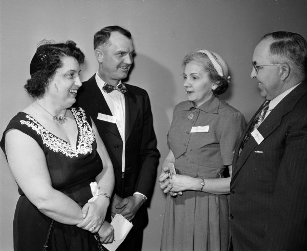 Two couples discuss mutual experiences as foster parents at a meeting for 120 Madison and Dane County foster parents. They include, left to right: Mrs. and Mr. Milo Schneider, Oregon, and Margaret and Joseph Zimmerman. The Schneiders are foster parents for the County Juvenile Court and the Zimmermans for the Catholic Welfare Bureau.