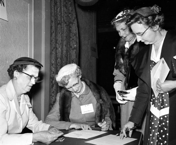 Shown at a registration table at the first annual convention of the Madison Diocesan Council of Catholic Women are, from left: Mrs. F.J. Sazma, Water Town; Mrs. Myron Trambly, Stoughton; Mrs. Ray Schhweigen, Jefferson, and Mrs. George Seuer, Watertown.