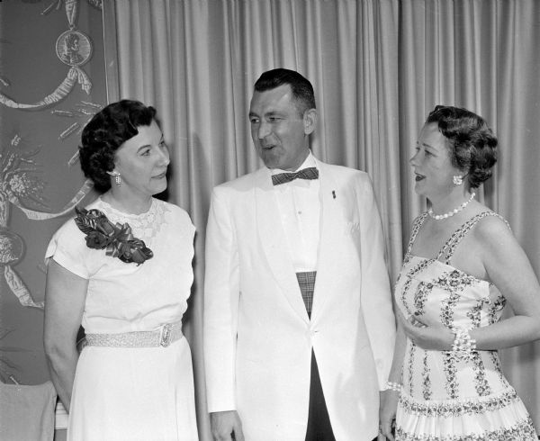 Sylvia Thomas, John Voss, and Ruth Voss chat between dances at the Knights of Columbus Formal spring dance. Mr. Voss was a faithful scribe of the Catholic men's organization.