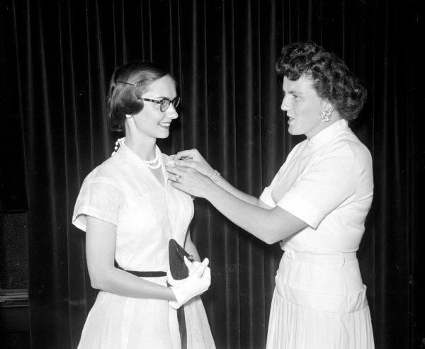 Jean Austin, right, pins a name card on Dorothy Behnisch at the ten year Class of 1945 Edgewood High School Reunion. The class presented a check as a gift for the Edgewood Chapel.