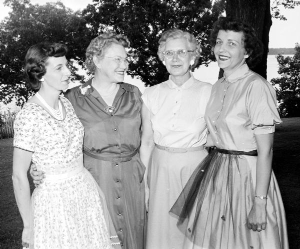 Mrs. Robert Fisher (left), Loretta Iler, Bertha Lewis, and Florence Fitzgerald standing in the yard of Forrest and Loretta Iler home during a benefit tea for the Madison Shrine No. 6, White Shrine of Jerusalem.
