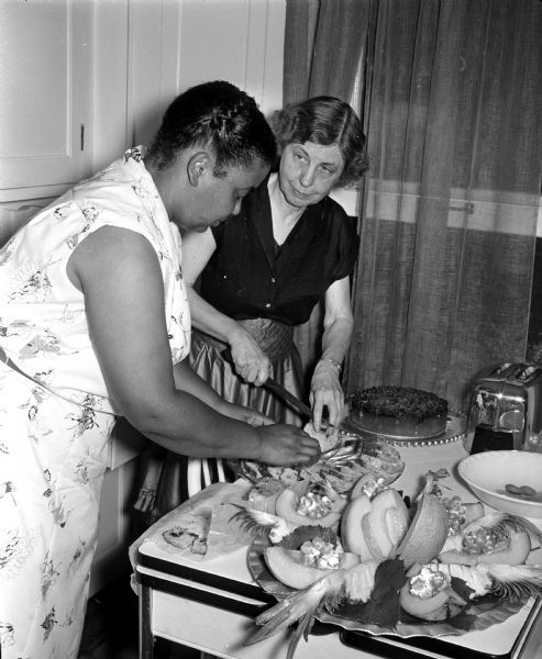 United Church Women board members attend a breakfast to honor their president, Mildred Campbell, who will be moving from Madison. At left, Irma Jenkins assists hostess Vera Browne in preparing the food.