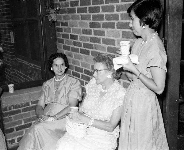 United Church Women board members attend a breakfast to honor their president, Mildred Campbell, who will be moving from Madison. Conversing on the porch while waiting for breakfast are, left to right: Glenny Morgan, Mrs. Ralph Butler, and Doris Mita.