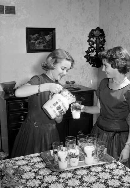 Madison High School girls hold a "Pot Luck Club" supper prior to a school event at the home of Mr. and Mrs. Howard Radder, 4102 Council Crest. Shown from left are West Junior High eighth graders Patty Radder and Jean Kelzenberg. The supper is a celebration of Patty's 13th birthday. Other club members are Virginia Crownhart, Barbara Harloff,  Sally Miles, Gail Gilbert, Jeanne Weatherly, Dace Briedis, Kathy Maloney, Nancy Larson, Kay Knick, Marion Amlie, and Margaret Eccles.