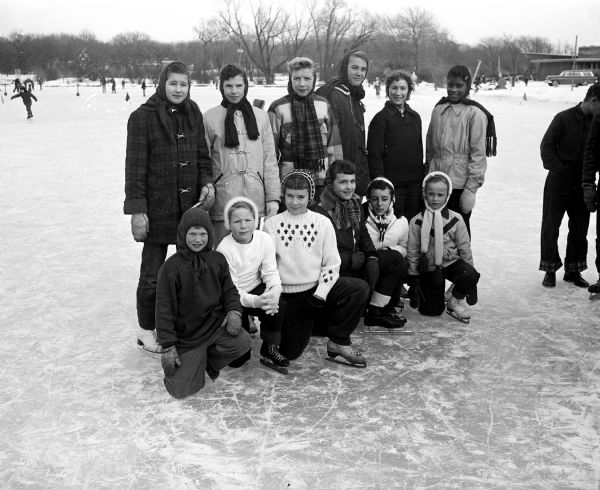 Group portrait of winners in the girls division of the Madison speed skating finals at Vilas Park. Front row, left to right:  Kristine Thomas, Alice Jean DuBois, Kay Kremer, Jo Ann Hermanson, Linda Karn and Susan Forrest.  Back row, left to right: Patty Parent, Peggy Ahlgren, Karen Hendricks, Cindy Way, Wendy Miller and Diane Hill.  Insert:  Carol Stokes  (left) and Kathy Stokes.