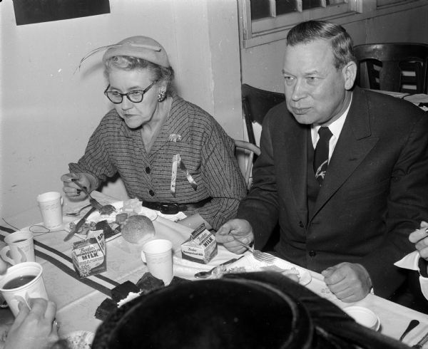 Wisconsin Secretary of State Mrs. John E. Wise sitting at the dinner table with the Republican Senator from Nebraska, Roman L. Hruska, during the annual Lincoln Day dinner at the Dane County Fairgrounds. Senator Hruska was the main speaker at the dinner.