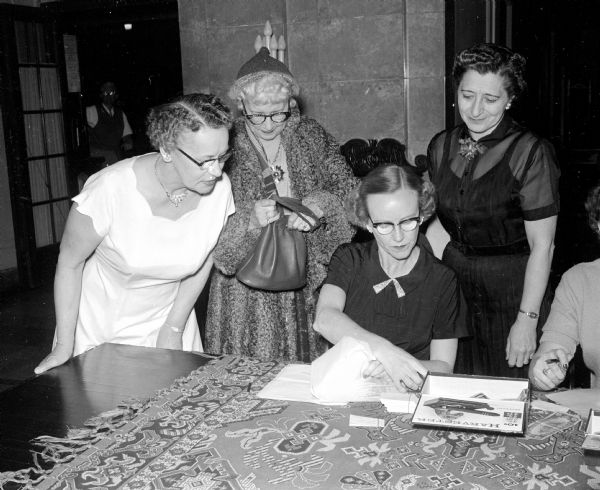 Ticket committee members Mrs. Russell Perry (left), Ruth Herthel, Mrs. Conrad Lindenlaub, and Mrs. Eldred Tygum attend the Madison Shrine Valentine Dinner at the Masonic Temple.
