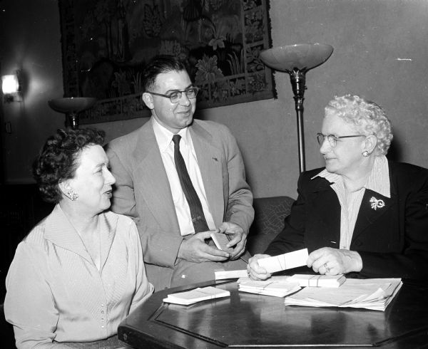 Three officials discuss the recently completed six-week term of the Madison School of Religion at the First Congregational Church. Dean of the school is Rev. Charles A. Rota (center). The women are Marian Miller (left), of the Christian education committee, and Erma Lonergan, school registrar.