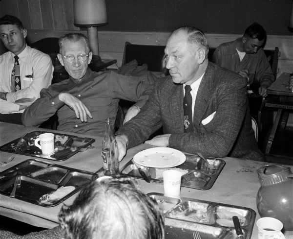 Trainer Walter Bakke visits with baseball coach Arthur Mansfield at a University of Wisconsin athletic department dinner hosted by maintenance foreman Joe Betlach.