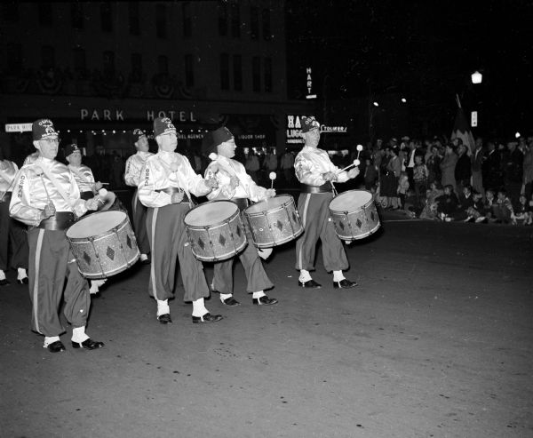 Osman Temple drummers from St. Paul, Minnesota take part in the Midwest Shrine parade as it moves around the corner of South Carroll and West Main Streets. The Park Hotel is in the background.