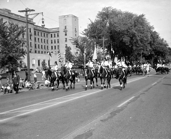 The famous Black Horse Patrol of the Medinah Temple of Chicago takes part in the Midwest Shrine parade as it moves along University Avenue in front of the old University Hospital.