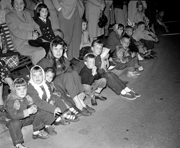 Children watch the parade from the curb at the Midwest Shrine parade.