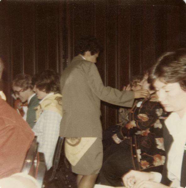 Vel Phillips, standing, talking to a woman sitting among a group of women seated in chairs.