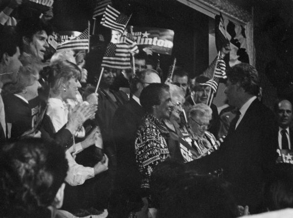 Vel Phillips, standing with a crowd, attending a political campaign meeting for Bill Clinton.