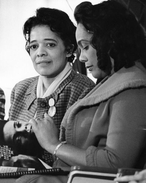 Vel Phillips sitting next to Coretta Scott King. Vel is wearing two button pins on her lapel. Coretta is holding in her lap the book "My Life with Martin Luther King, Jr." that she authored.