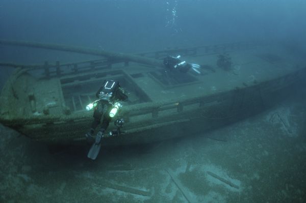 Underwater overhead view of the schooner <i>Home</i> taken from the starboard side near the stern. Two underwater archeologists are swimming over the site of the ship.