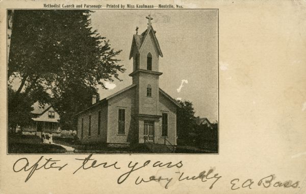 A woman and girl stand on the sidewalk leading along the side of the Methodist church from the parsonage to the street. There is a man near the wood frame church building. The church has a steeple topped with two crosses. The written inscription reads: "After ten years very truly EA Bass." The card was mailed to Rev. C.A. Stockwell, Tillamook, Oregon. Rev. Stockwell had presided over Methodist congregations in Wisconsin prior to moving to Oregon. E.A. Bass was a physician in Montello and was, himself, an amateur photographer. Caption reads: "Methodist Church and Parsonage — Printed by Miss Kaurfmann — Montello, Wis."