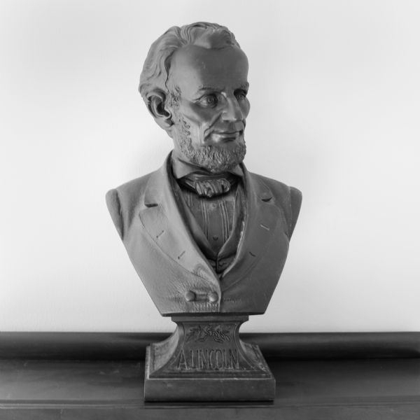 Cast metal bust of Abraham Lincoln sitting on a desk. 