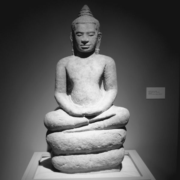Thai statue of "Buddha Seated on Naga." The statue is made from sandstone and is on display at the Chazen Museum.