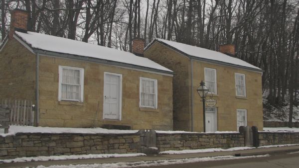Exterior view of Pendarvis House and Trelawny House on Shake Rag Street, which were once Cornish miners's houses. There is snow on the ground and on the roof.