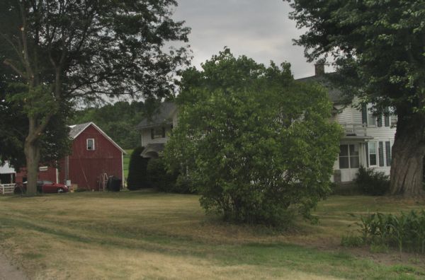 View of the Tower Rock Farm, which is owned by the Gasser family. A large bush obscures the view of the house.
