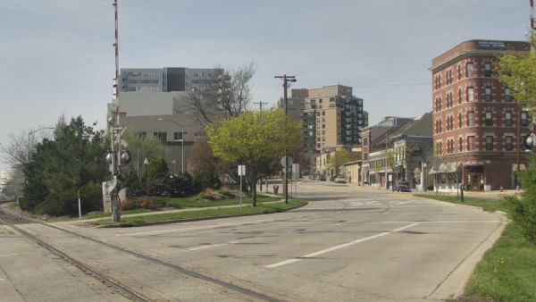 View down East Wilson Street across the railroad tracks towards condominiums and businesses on the 400 block, including the Cardinal Bar & Cafe at 418 East Wilson Street.