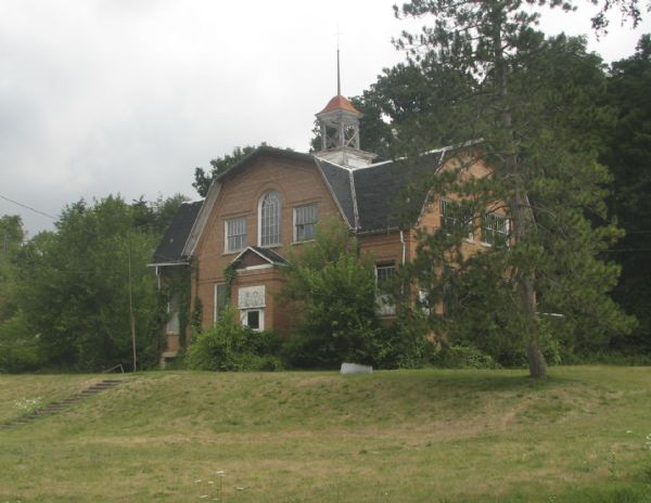 Exterior view of the public school, positioned on a small hill.