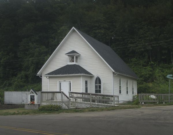 Exterior view of the Methodist Evangelical Church, with stairs and a ramp at the front of the building.