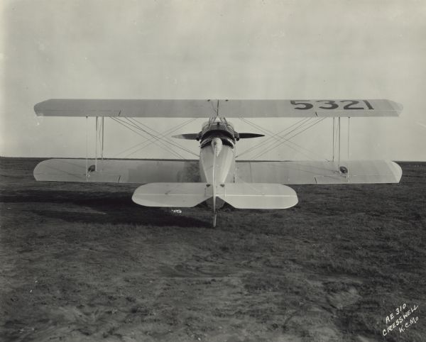 Rear view of an American Eagle sitting in a field. The tail identifier reads: "5321." The airplane body has a distinctive shiny steel texture with a circular pattern around the nose and the cockpits.