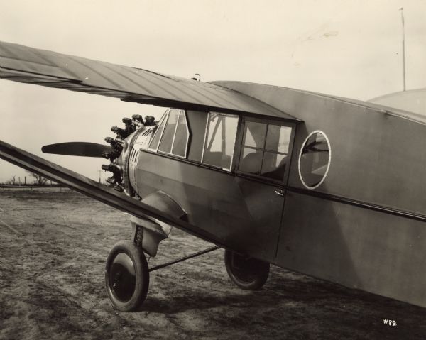 Three-quarter left side view from rear of front section of a Bellanca CH Pacemaker, showing arrangement of doors and windows. The cabin monoplane seats six passengers, sliding windows of non-shatterable glass, a cabin that is electrically-lighted and heated by engine exhaust.