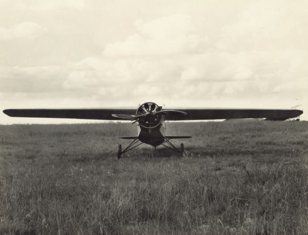 Front view of a Cessna Model A sitting on a field.