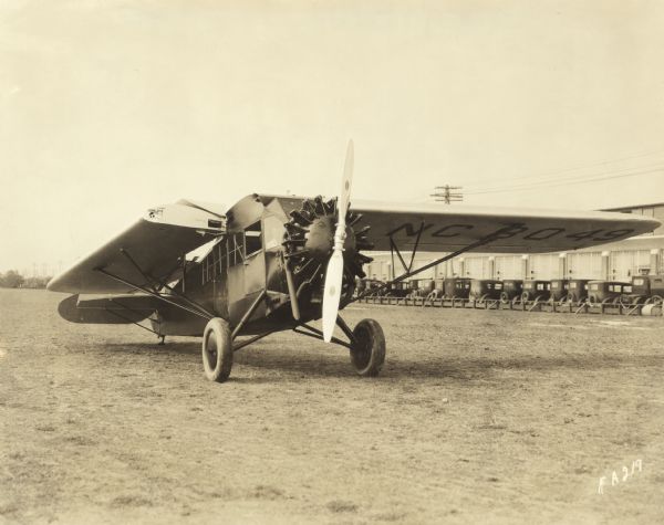 Three-quarter front right view of a Fairchild Model 61 (built with Wasp engine) sitting on a runway. The left wing is folded back against the tail, a feature that allows for easier storage. The wing identifier reads: "NC 8049."