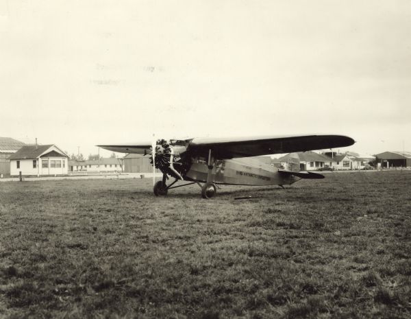 Three-quarter view from front left of a Fokker Super Universal sitting on a runway. The tail identifier reads: "NC 4453." Printed on the side of the airplane is the name: "The Virginia," and "Byrd Antarctic Expedition." The "Virginia" took part in the Byrd expedition to the Antarctic in 1928, and was flown by pilot Bernt Balchen. The airplane was destroyed by a storm while in Antarctica ca. March 1929.