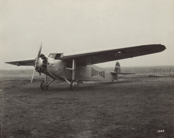 Three-quarter view from front left of a Fokker Super Universal monoplane sitting on a runway. The airplane is powered with a 410 hp Pratt & Whitney "Wasp" motor, and is equipped with seating for 5-6 passengers and an enclosed cockpit for two pilots. The mail and baggage compartment is located aft the cabin. The tail identifier reads: "NC 9729." The airplane is owned by Deep Rock Oil Co., and painted on the side is: "Deep-Rock."